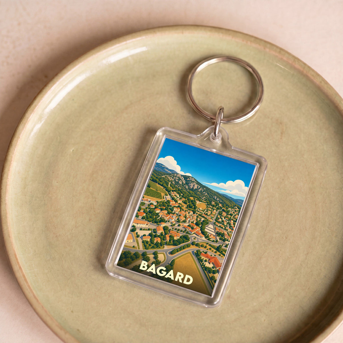 Porte-clés souvenir de la ville de Bagard avec une illustration stylisée vue du ciel.