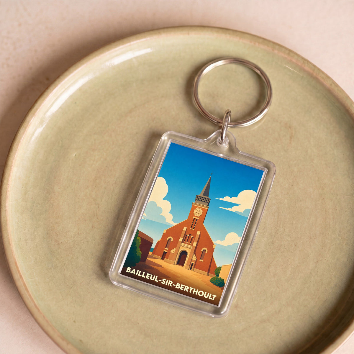 Porte-clés souvenir de la ville de Bailleul-Sir-Berthoult avec une illustration stylisée de son église.