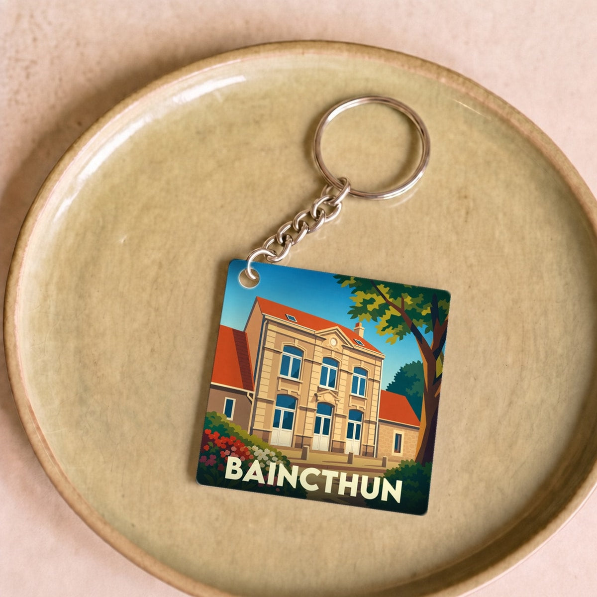 Porte-clés souvenir de la ville de Baincthun avec une illustration stylisée de sa mairie.