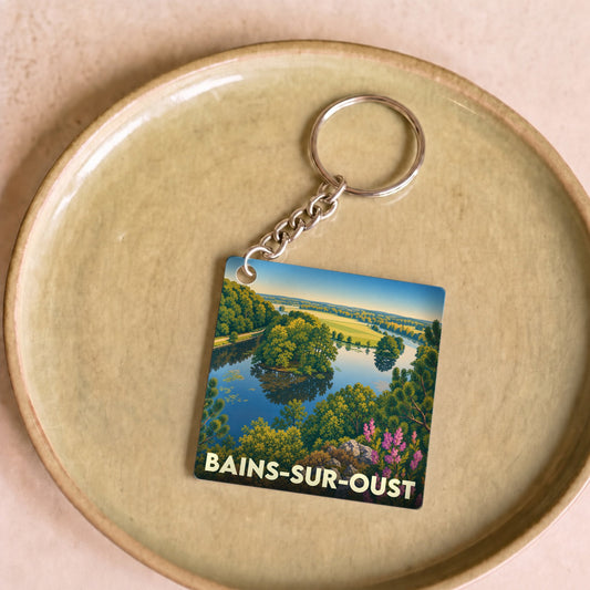 Porte-clés souvenir de la ville de Bains-sur-Oust avec une illustration de paysage colorée.