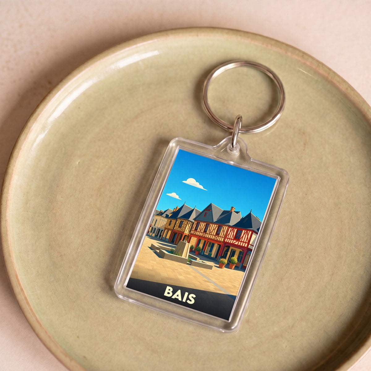 Porte-clés souvenir de la ville de Bais avec une illustration stylisée.
