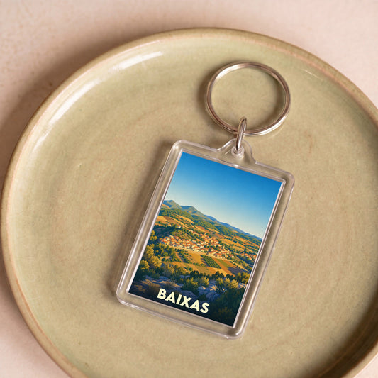 Porte-clés souvenir de la ville de Baixas avec une illustration stylisée de son paysage vallonné.