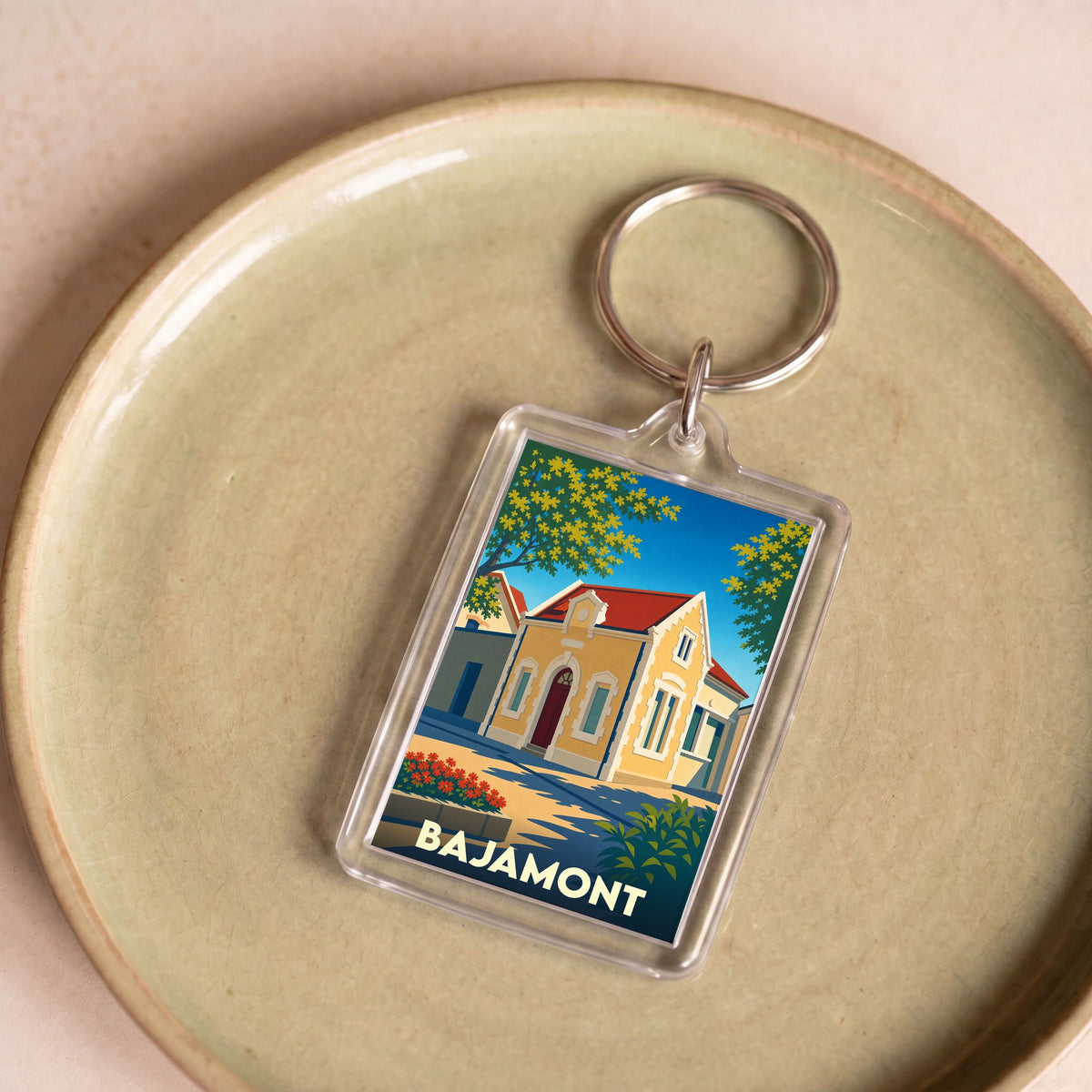 Porte-clés souvenir de la ville de Bajamont avec une illustration stylisée.