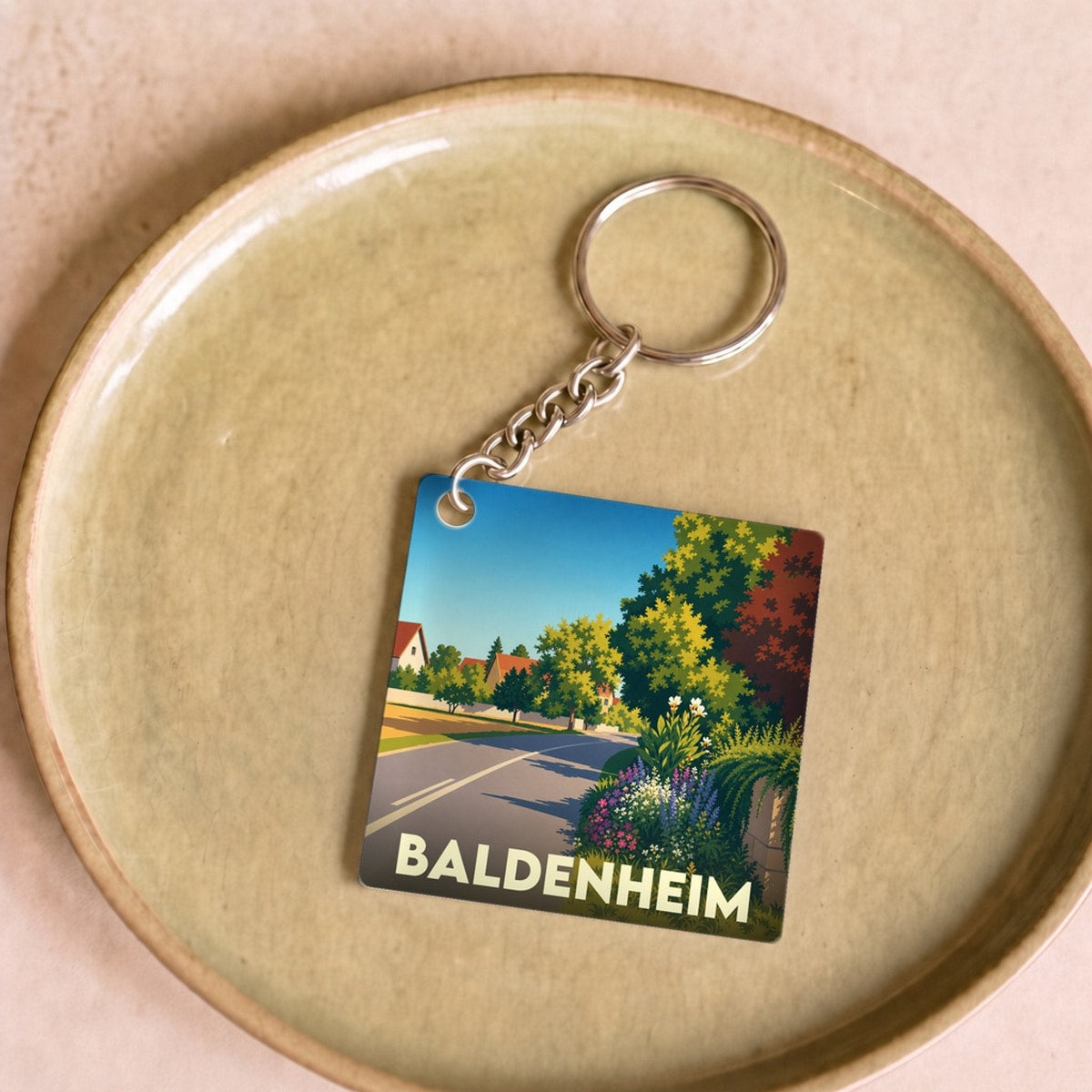 Porte-clés souvenir de la ville de Baldenheim avec une illustration paysagère stylisée.