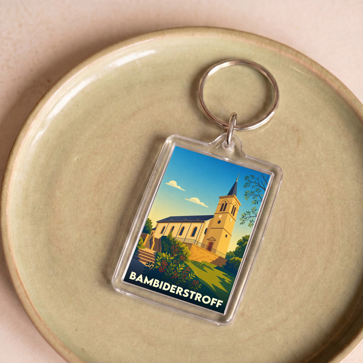 Porte-clés souvenir de la ville de Bambiderstroff avec une illustration stylisée de son église.
