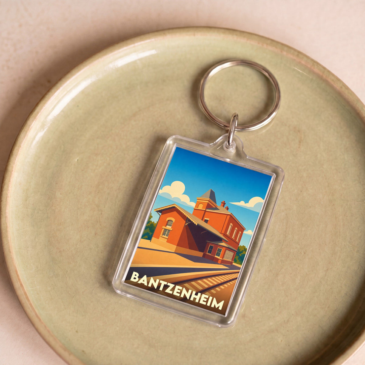 Porte-clés souvenir de la ville de Bantzenheim avec une illustration stylisée de sa gare.