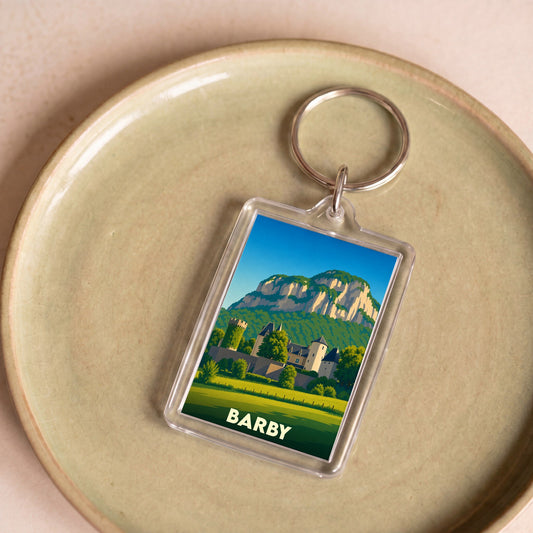 Porte-clés souvenir de la ville de Barby avec une illustration stylisée de son château et des montagnes environnantes.