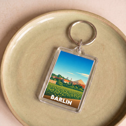 Porte-clés souvenir de la ville de Barlin avec une illustration stylisée de son paysage.