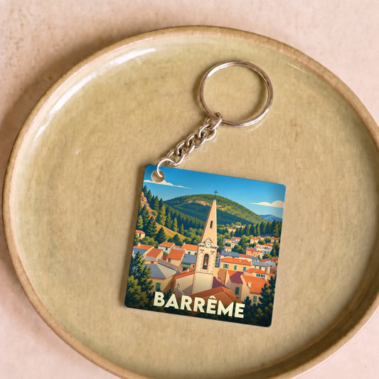 Porte-clés souvenir de la ville de Barrême avec une illustration stylisée de son clocher et de ses montagnes.