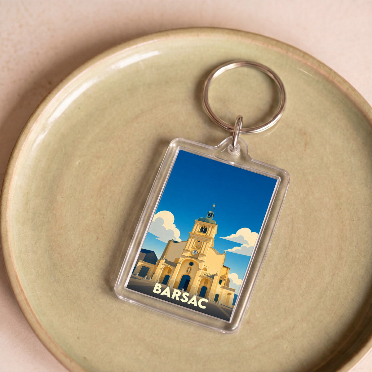 Porte-clés souvenir de la ville de Barsac avec une illustration stylisée de son église.