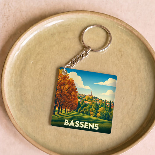 Porte-clés souvenir de la ville de Bassens avec une illustration paysagère stylisée.