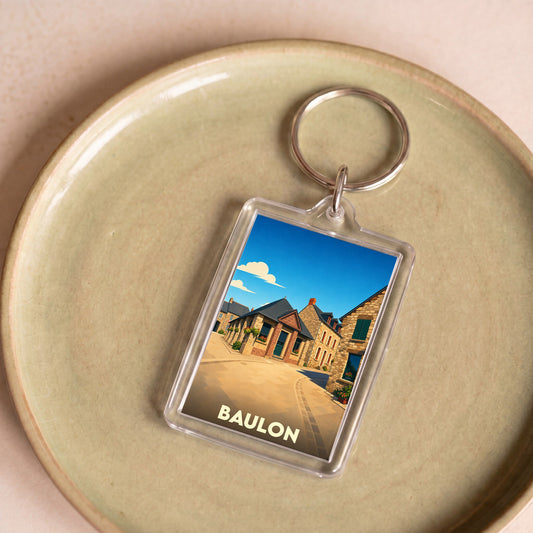 Porte-clés souvenir de la ville de Baulon avec une illustration stylisée.