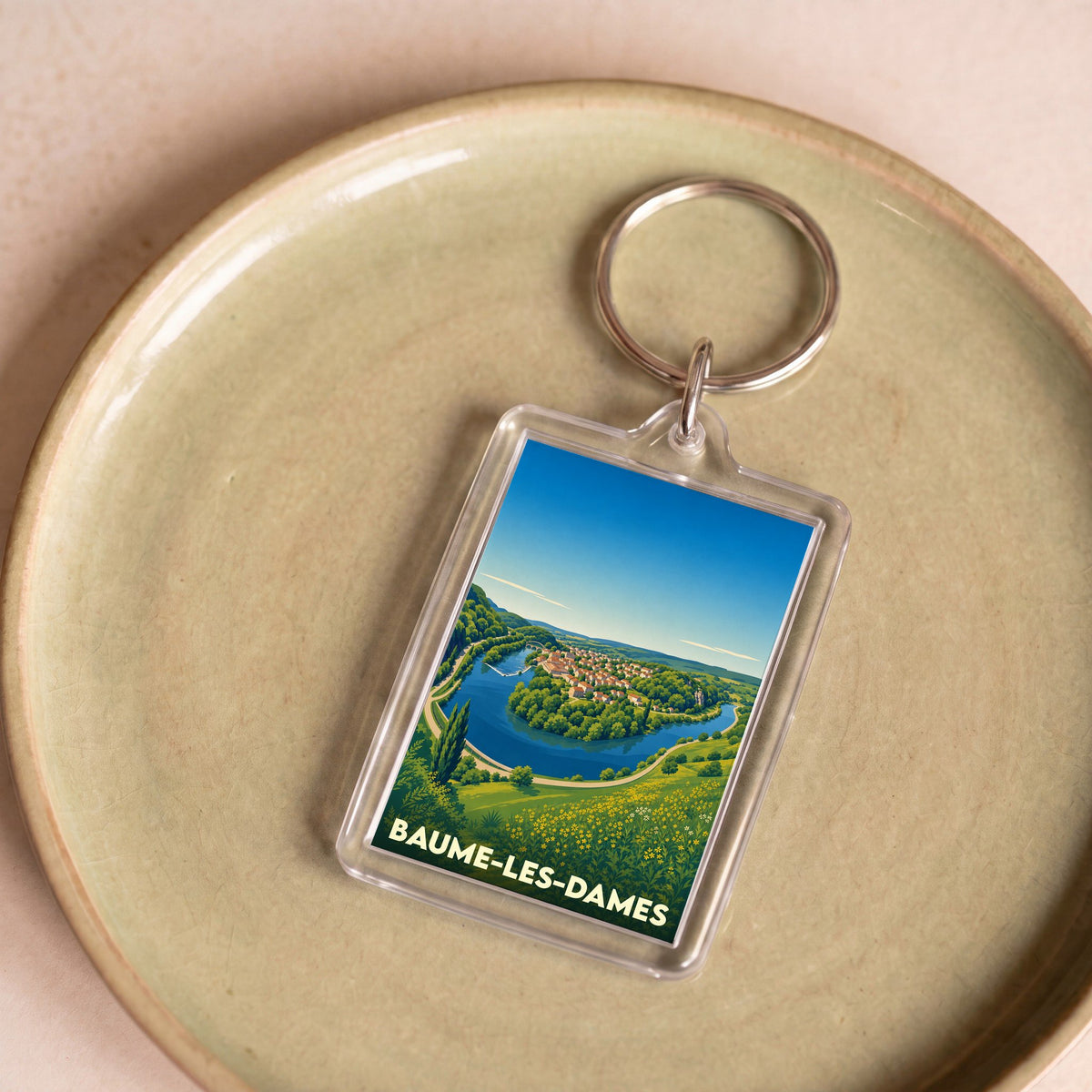 Porte-clés souvenir de la ville de Baume-les-Dames avec une illustration stylisée de la boucle du Doubs.