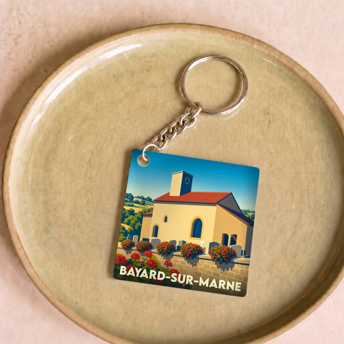 Porte-clés souvenir de la ville de Bayard-sur-Marne avec une illustration stylisée d'un bâtiment fleuri.