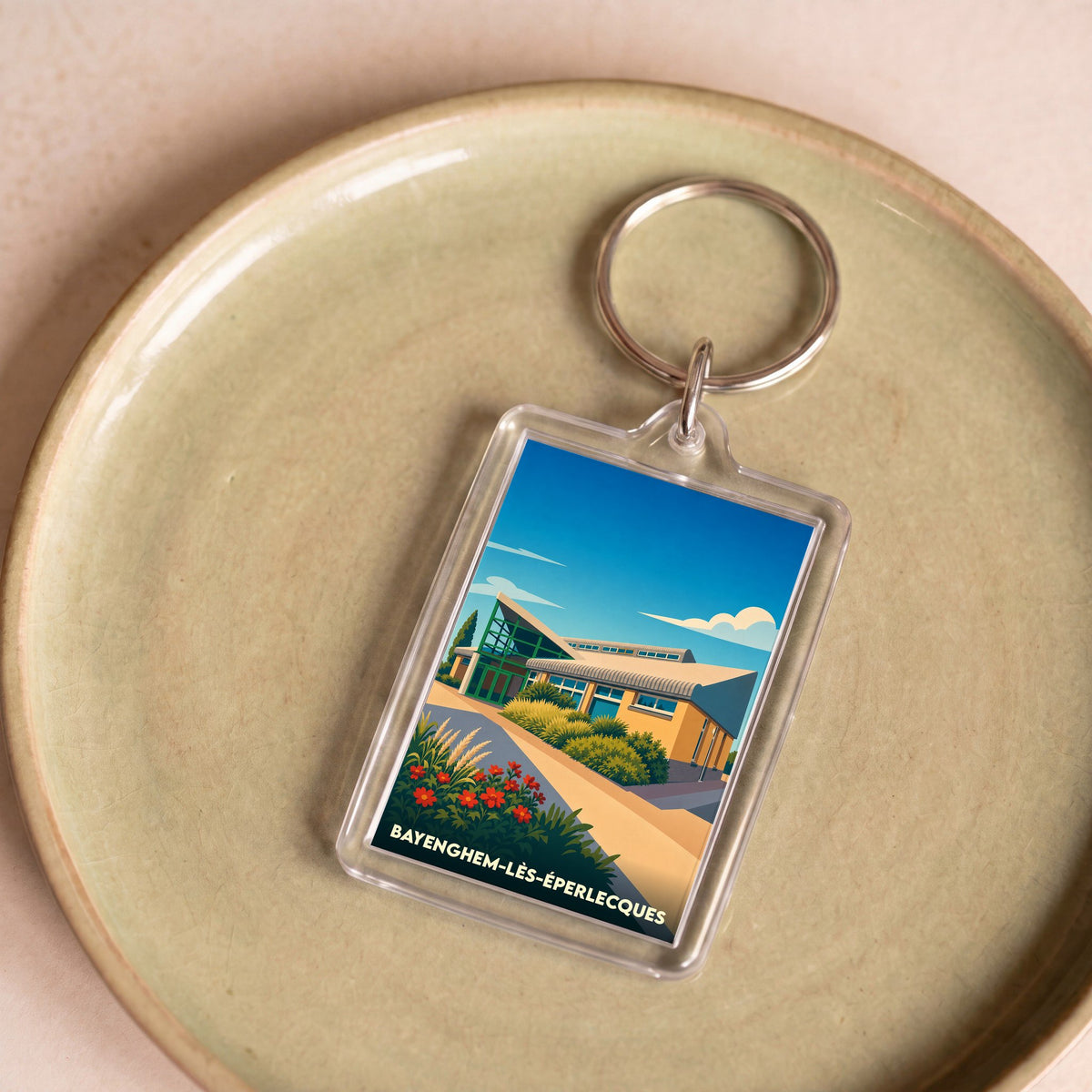 Porte-clés souvenir de la ville de Bayenghem-lès-Éperlecques avec une illustration stylisée.