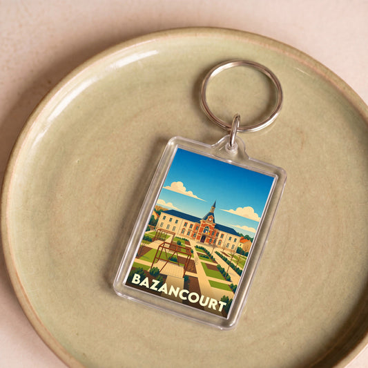 Porte-clés souvenir de la ville de Bazancourt avec une illustration stylisée de sa mairie et de ses jardins.