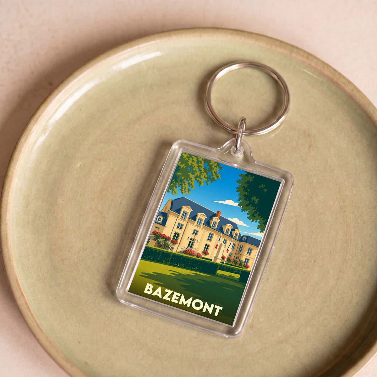 Porte-clés souvenir de la ville de Bazemont avec une illustration stylisée d'un château.