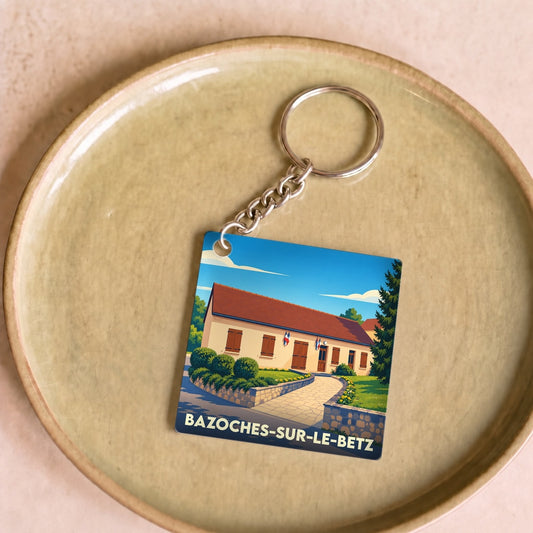 Porte-clés souvenir de la ville de Bazoches-sur-le-Betz avec une illustration stylisée.