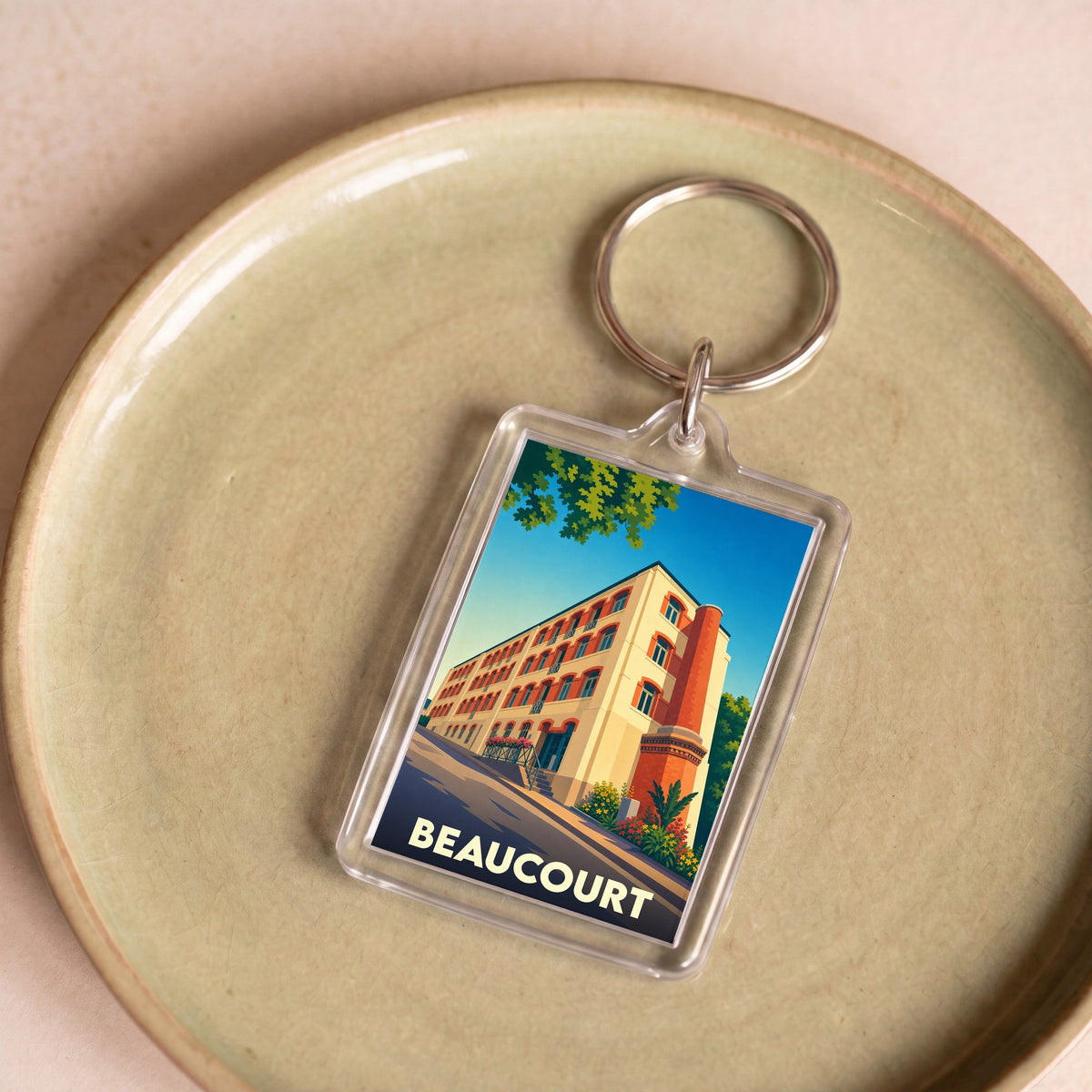 Porte-clés souvenir de la ville de Beaucourt avec une illustration stylisée.
