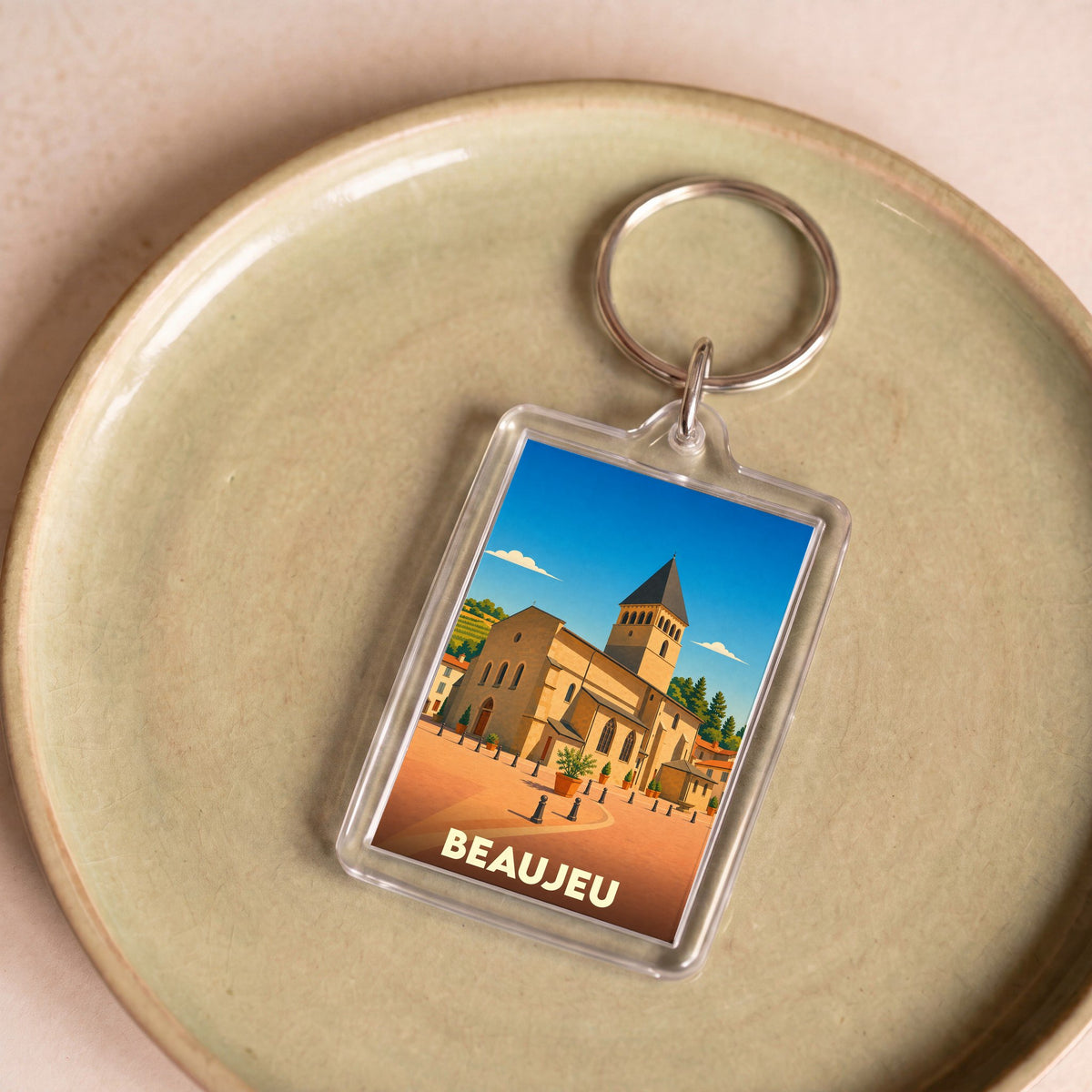 Porte-clés souvenir de la ville de Beaujeu avec une illustration stylisée de son église historique.