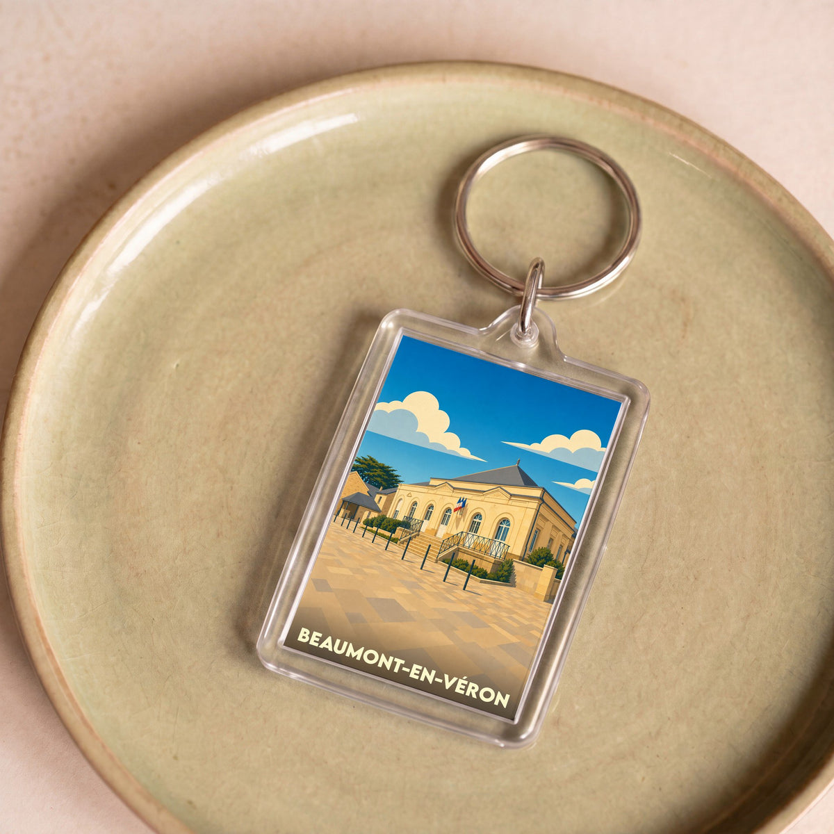 Porte-clés souvenir de la ville de Beaumont-en-Véron avec une illustration stylisée.