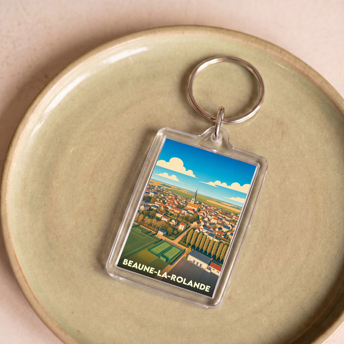 Porte-clés souvenir de la ville de Beaune-la-Rolande avec une illustration stylisée.