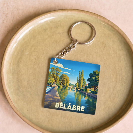 Porte-clés souvenir de la ville de Bélâbre avec une illustration stylisée d'un paysage fluvial.