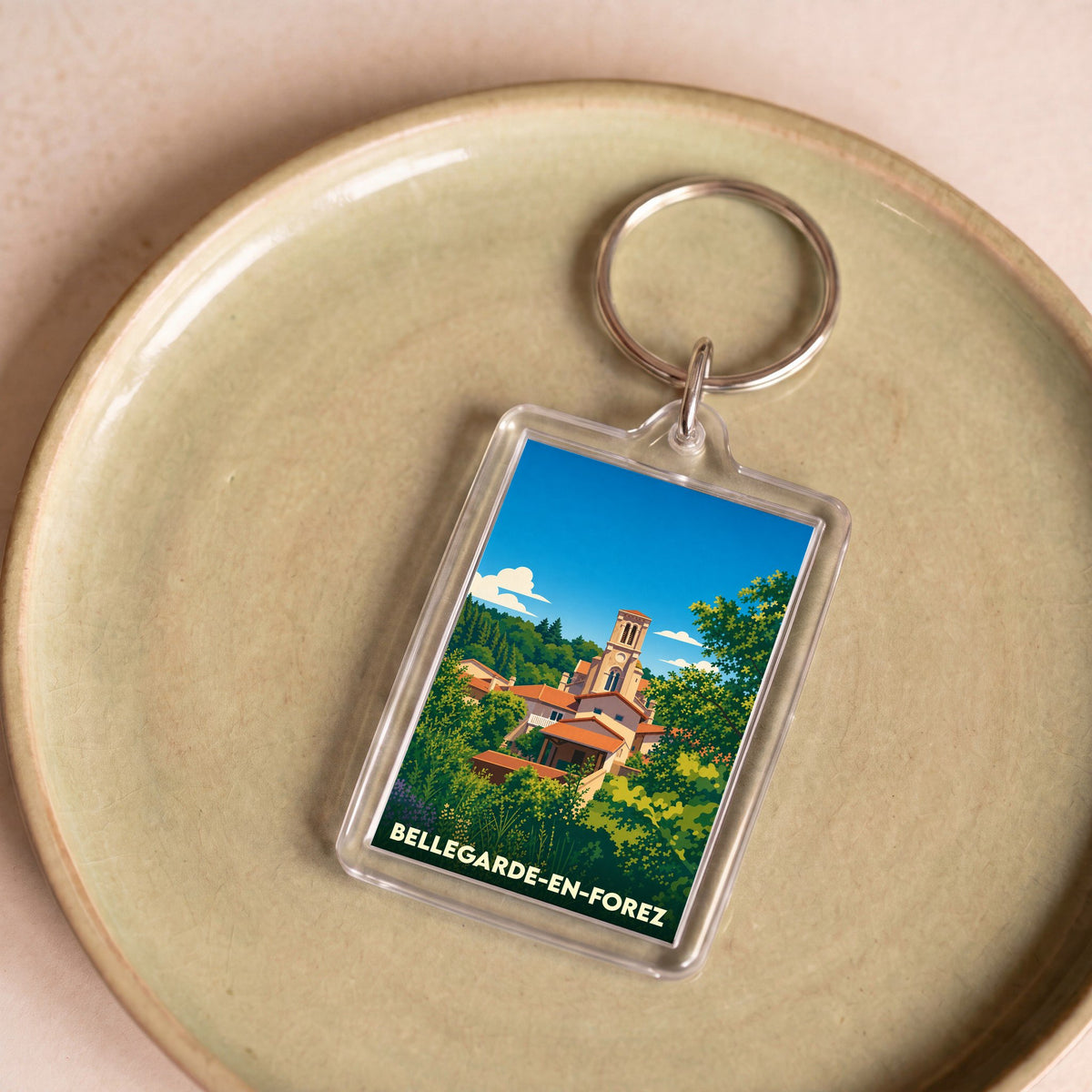 Porte-clés souvenir de Bellegarde-en-Forez avec une illustration stylisée de la ville dans un cadre transparent.