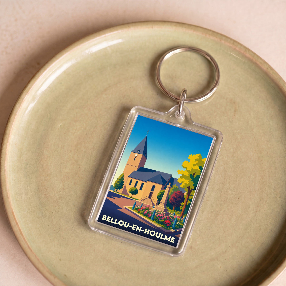 Porte-clés souvenir de la ville de Bellou-en-Houlme avec une illustration stylisée.