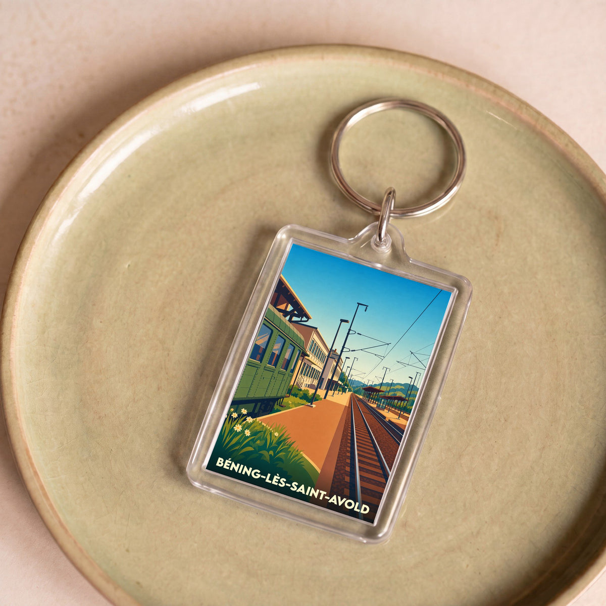 Porte-clés souvenir de la ville de Béning-lès-Saint-Avold avec une illustration stylisée de sa gare.