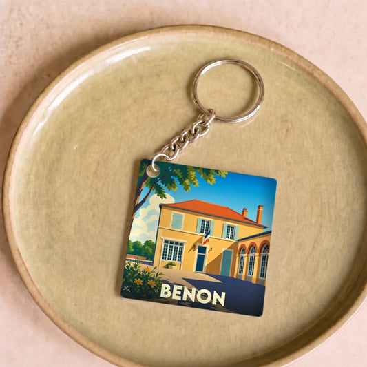 Porte-clés souvenir de la ville de Benon avec une illustration stylisée d'un bâtiment typique.