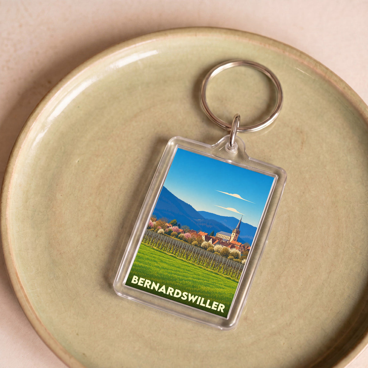 Porte-clés souvenir de la ville de Bernardswiller avec une illustration stylisée d'un paysage alsacien.