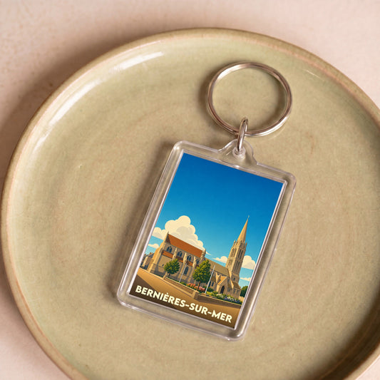 Porte-clés souvenir de la ville de Bernières-sur-Mer avec une illustration stylisée de son église.