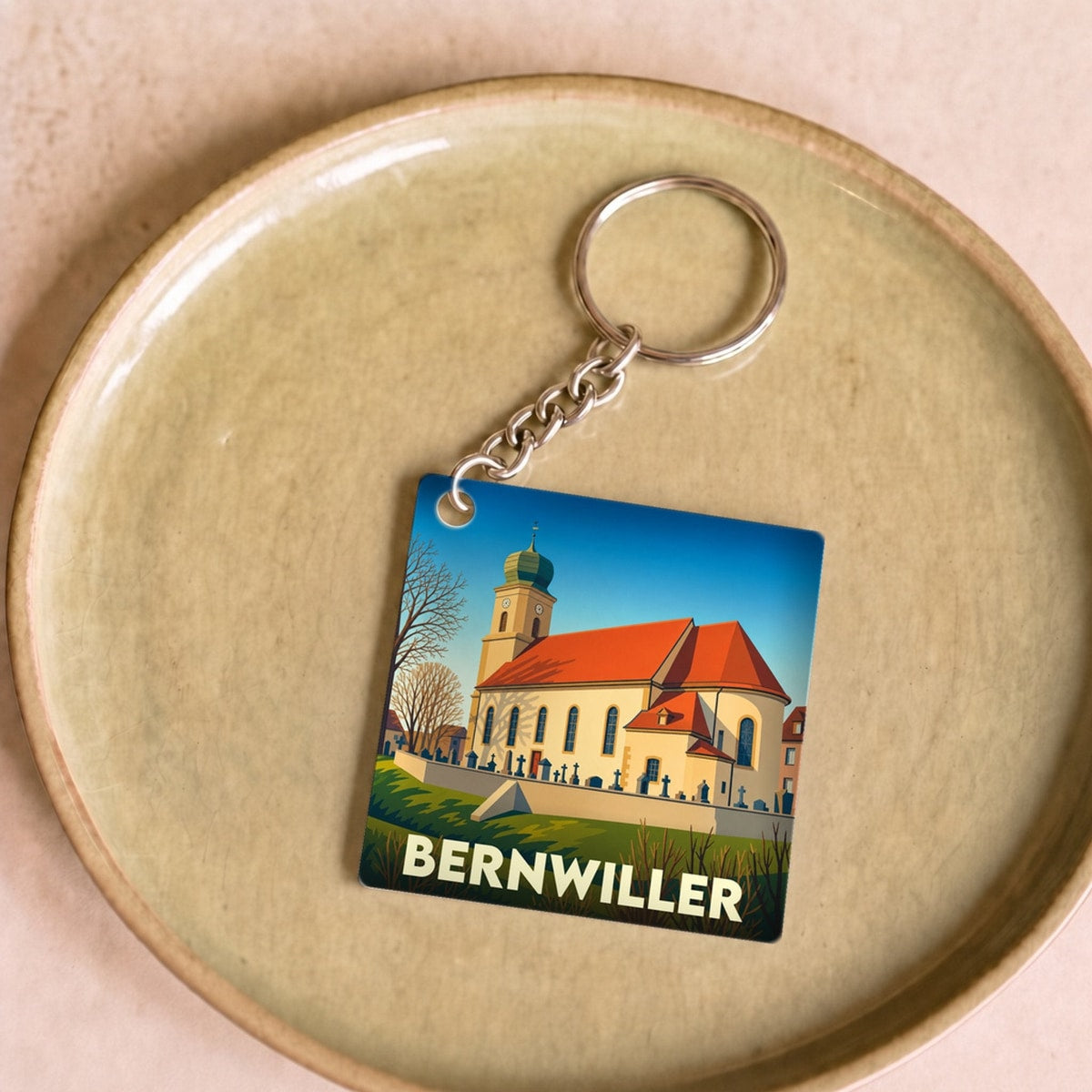 Porte-clés souvenir de la ville de Bernwiller avec une illustration stylisée de son église.