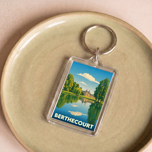 Porte-clés souvenir de la ville de Berthecourt avec une illustration stylisée d'un château se reflétant dans l'eau.