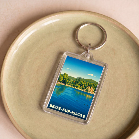 Porte-clés souvenir de la ville de Besse-sur-Issole avec une illustration stylisée d'un lac bordé de verdure.