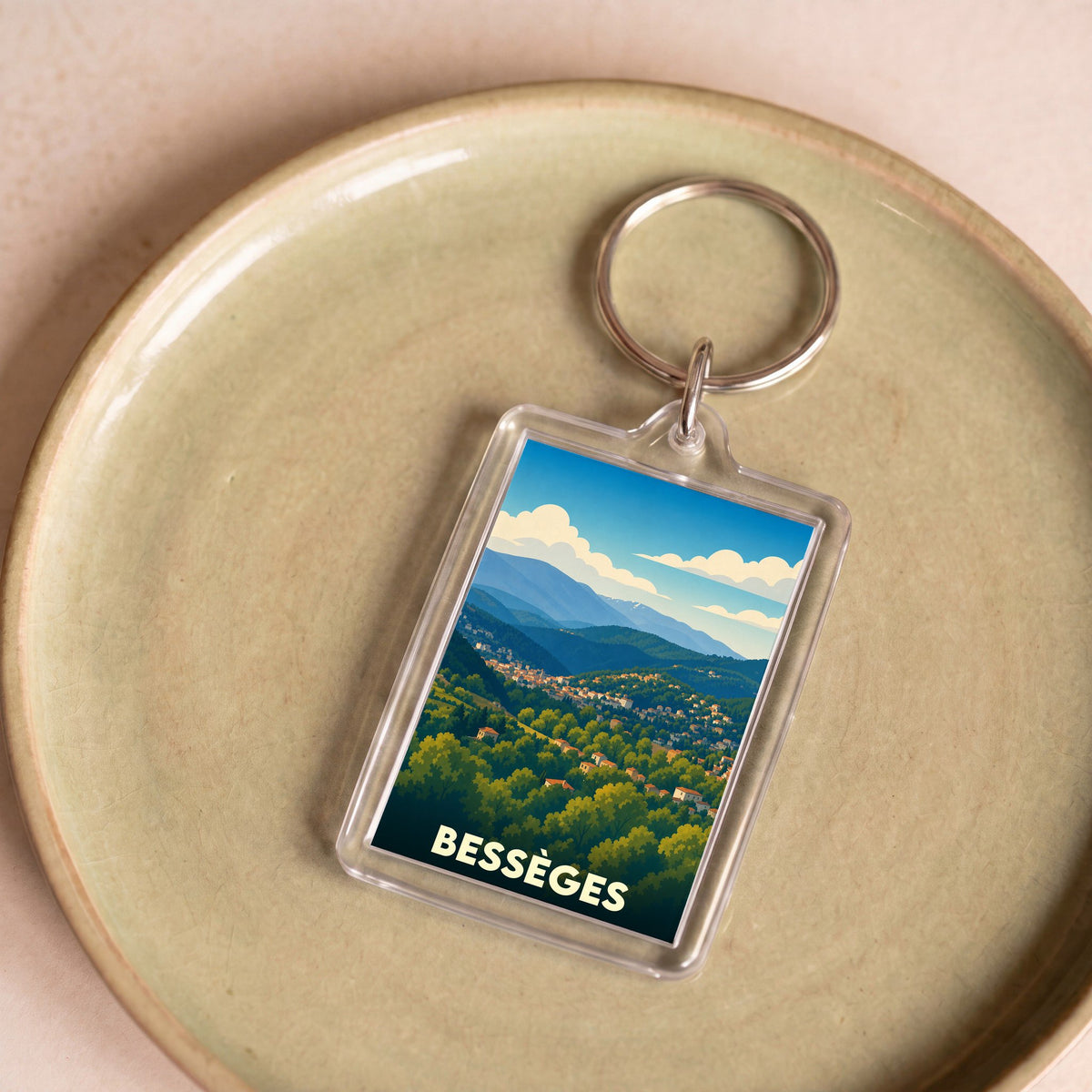 Porte-clés souvenir de la ville de Bessèges avec une illustration stylisée de son paysage vallonné.
