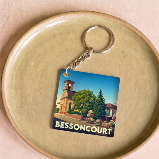 Porte-clés souvenir de la ville de Bessoncourt avec une illustration stylisée de son église et de ses fleurs.