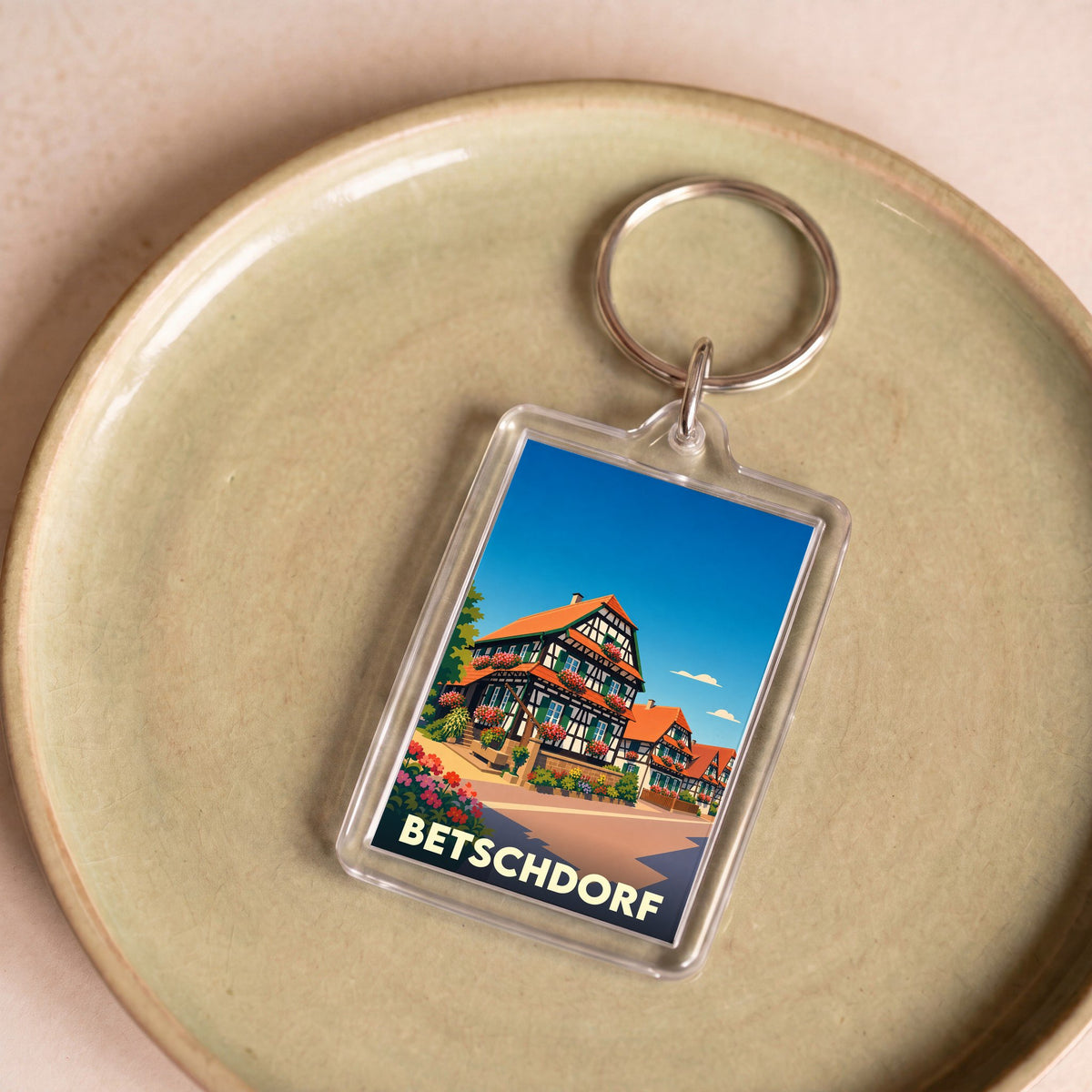 Porte-clés souvenir de la ville de Betschdorf avec une illustration stylisée de maisons à colombages.