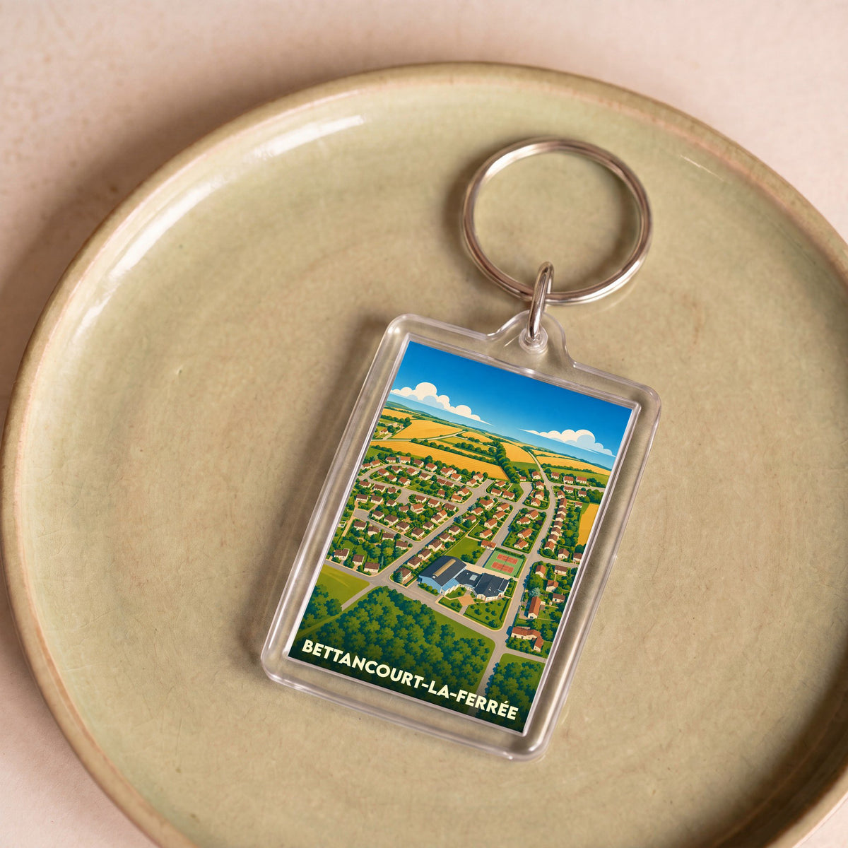 Porte-clés souvenir de la ville de Bettancourt-la-Ferrée avec une illustration stylisée vue du ciel.