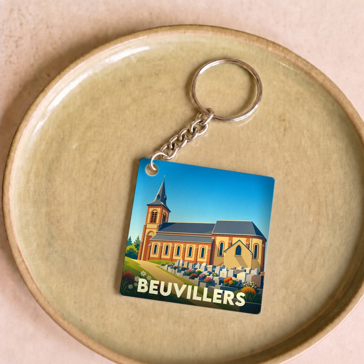 Porte-clés souvenir de la ville de Beuvillers avec une illustration stylisée de son église.