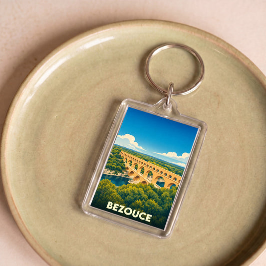 Porte-clés souvenir de la ville de Bezouce avec une illustration stylisée du Pont du Gard.