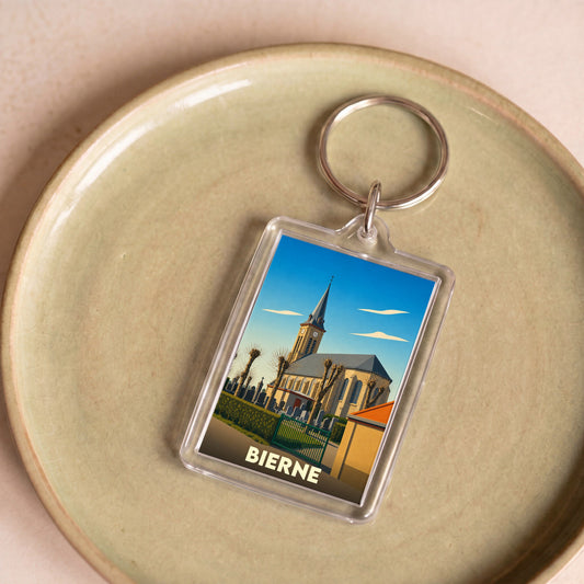 Porte-clés souvenir de la ville de Bierne avec une illustration stylisée de son église.