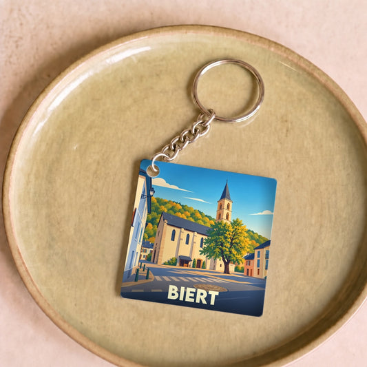 Porte-clés souvenir de la ville de Biert avec une illustration stylisée.