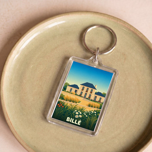 Porte-clés souvenir de la ville de Billé avec une illustration stylisée d'une maison de campagne.