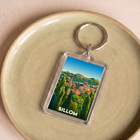 Porte-clés souvenir de la ville de Billom orné d'une illustration stylisée du paysage urbain et de sa campagne.