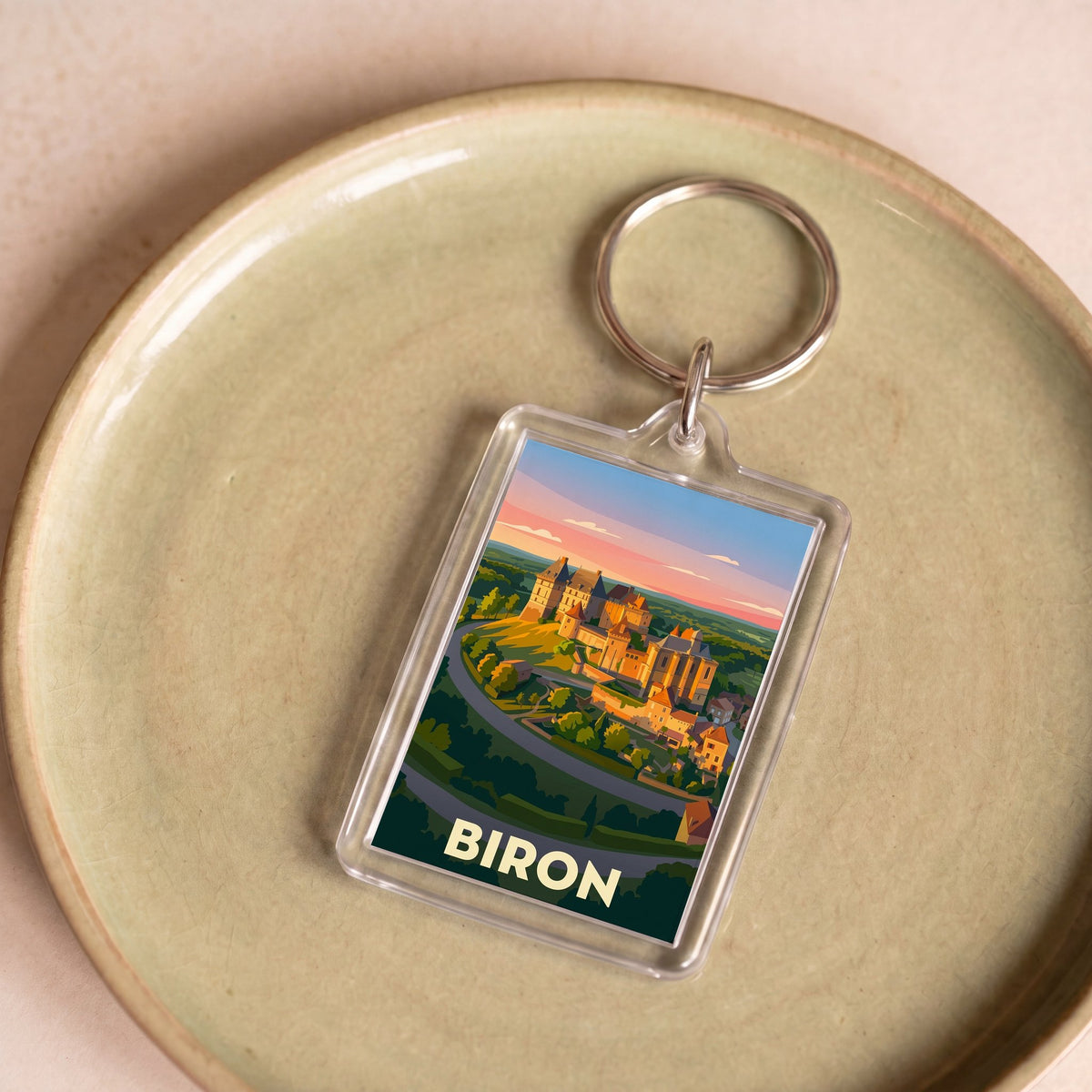 Porte-clés souvenir de la ville de Biron avec une illustration stylisée.