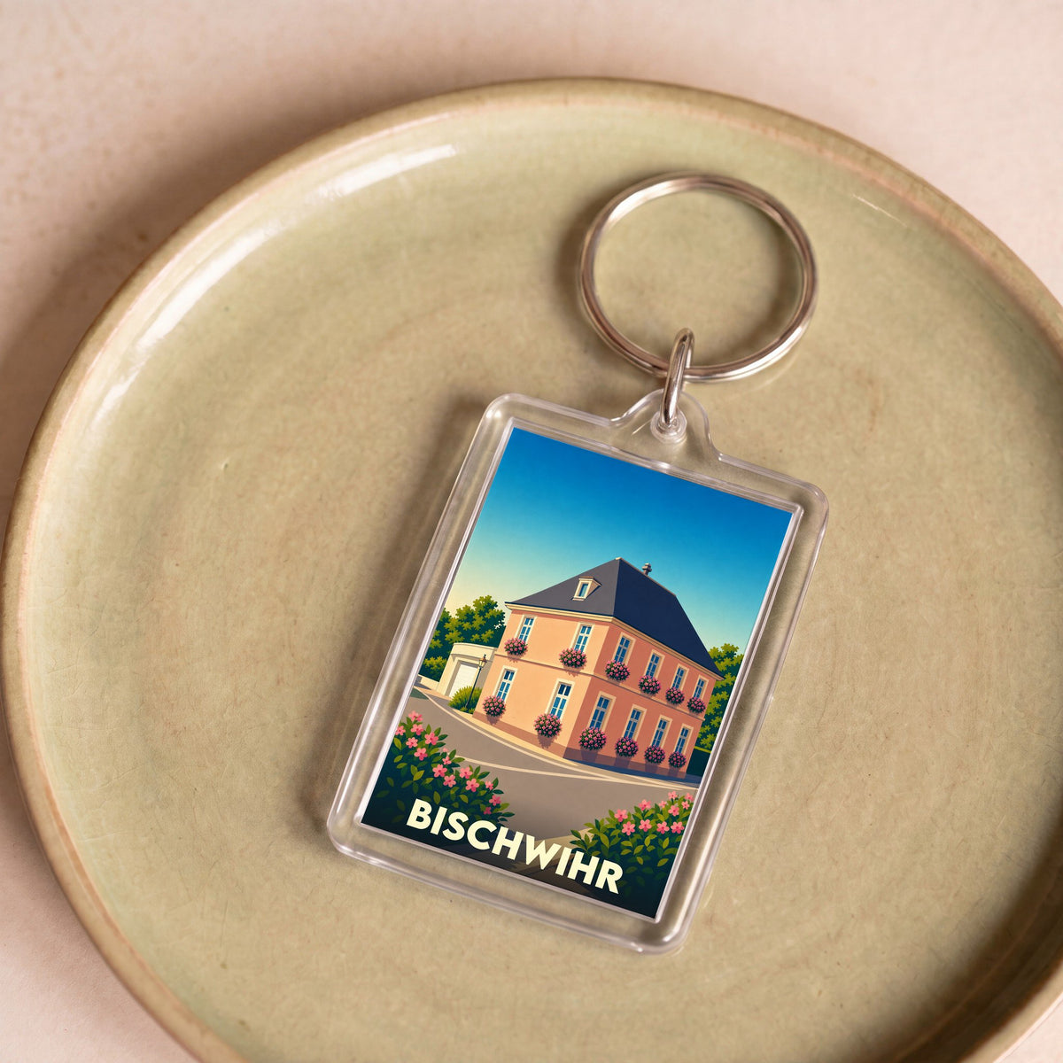 Porte-clés souvenir de la ville de Bischwihr avec une illustration stylisée d'une maison fleurie.