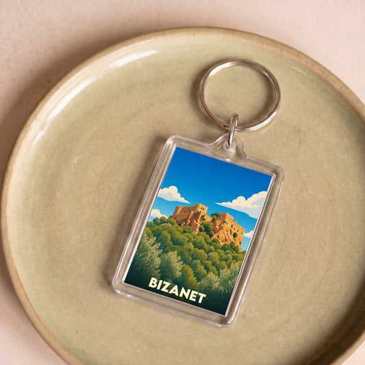 Porte-clés souvenir de la ville de Bizanet avec une illustration stylisée d'un château sur une colline.