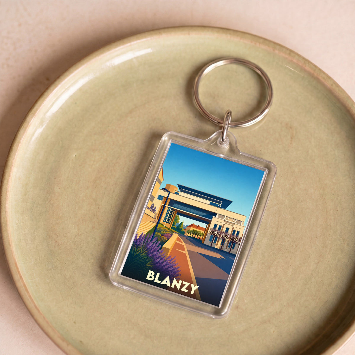 Porte-clés souvenir de la ville de Blanzy avec une illustration stylisée.